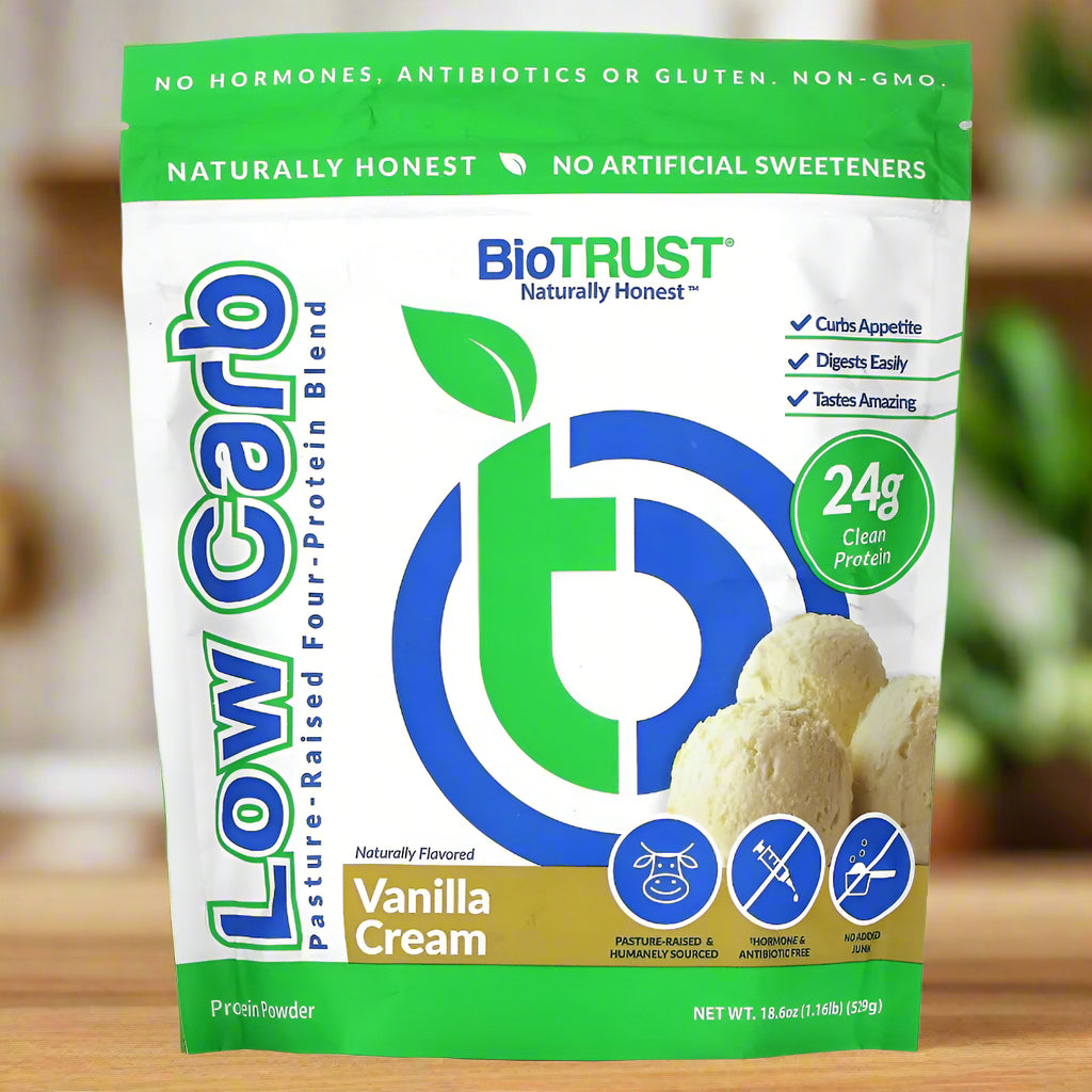 BiOTRUST Low Carb Vanilla Cream protein powder package on a wooden surface with a blurred background