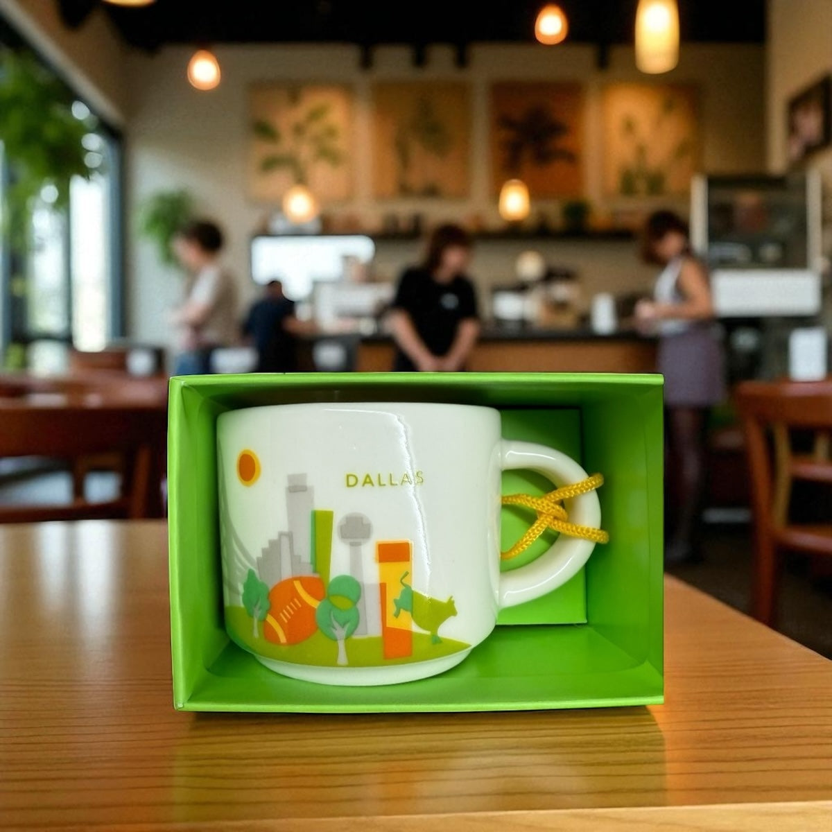 Mug with Dallas design in a green box on a table in a cafe.